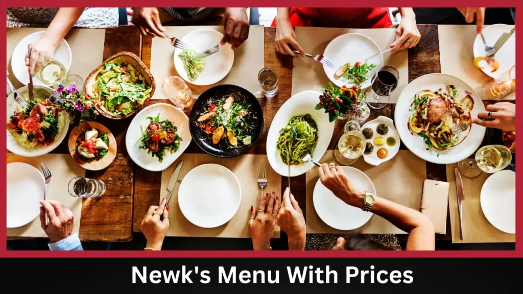 A group of people sitting around a wooden table enjoying various salads and pasta dishes from Newk's Menu With Prices, with drinks and flowers, viewed from above. Newk's Menu With Prices